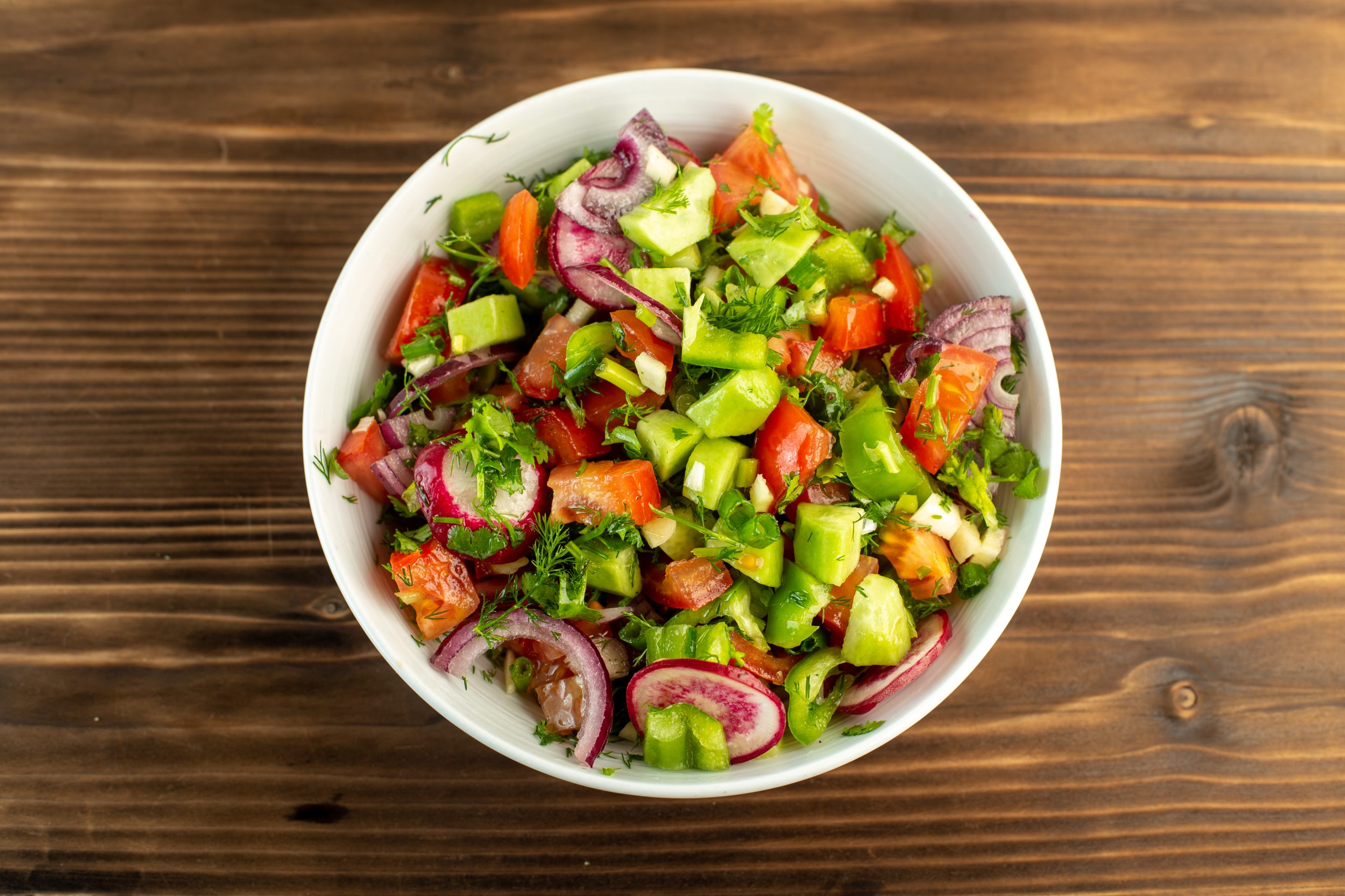 Alimentation - légumes-frais-couleurs-tranchés-concombres-tomates-rouges-oignons-surface-bois-rustique