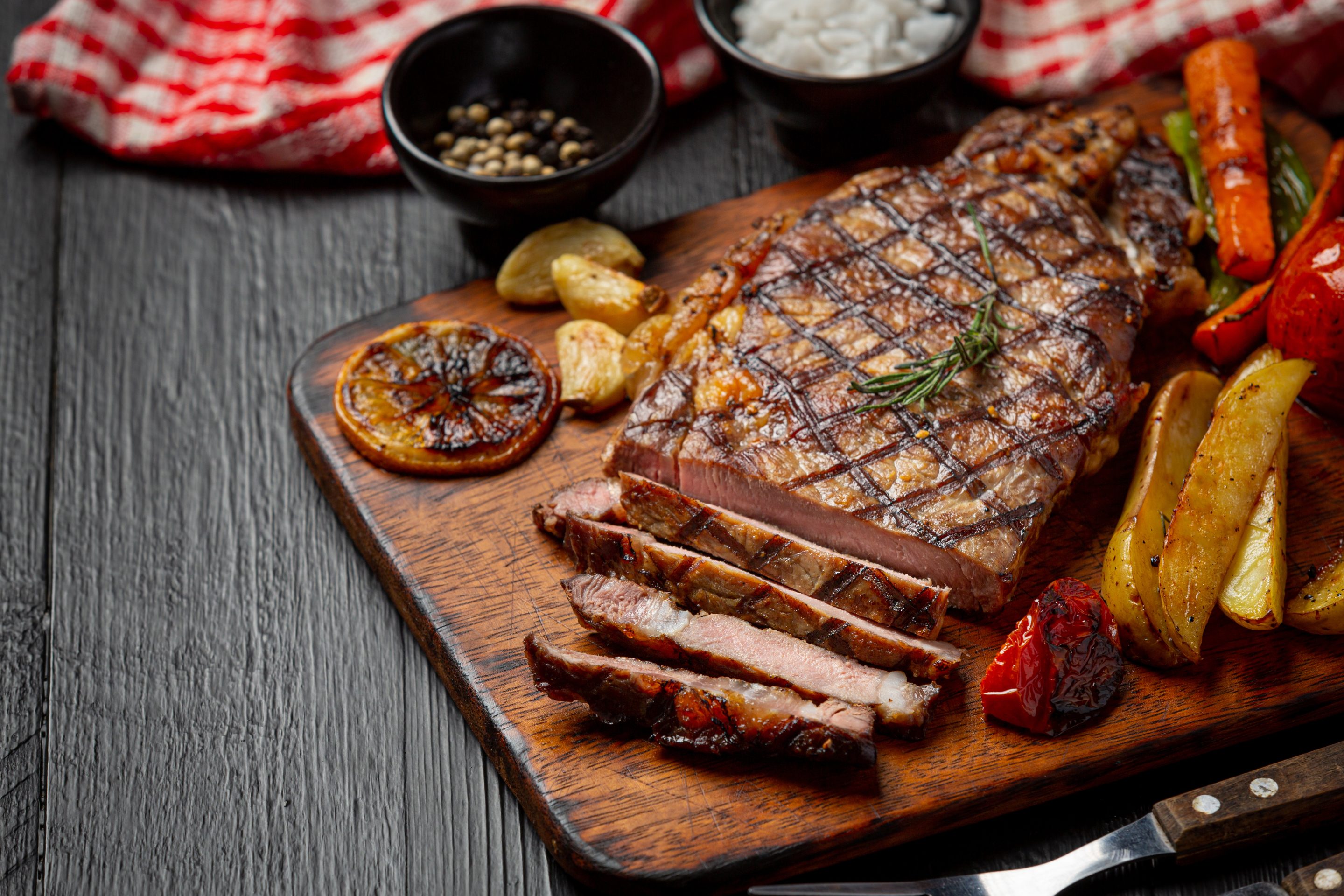 Steak de bœuf grillé sur fond de bois foncé.