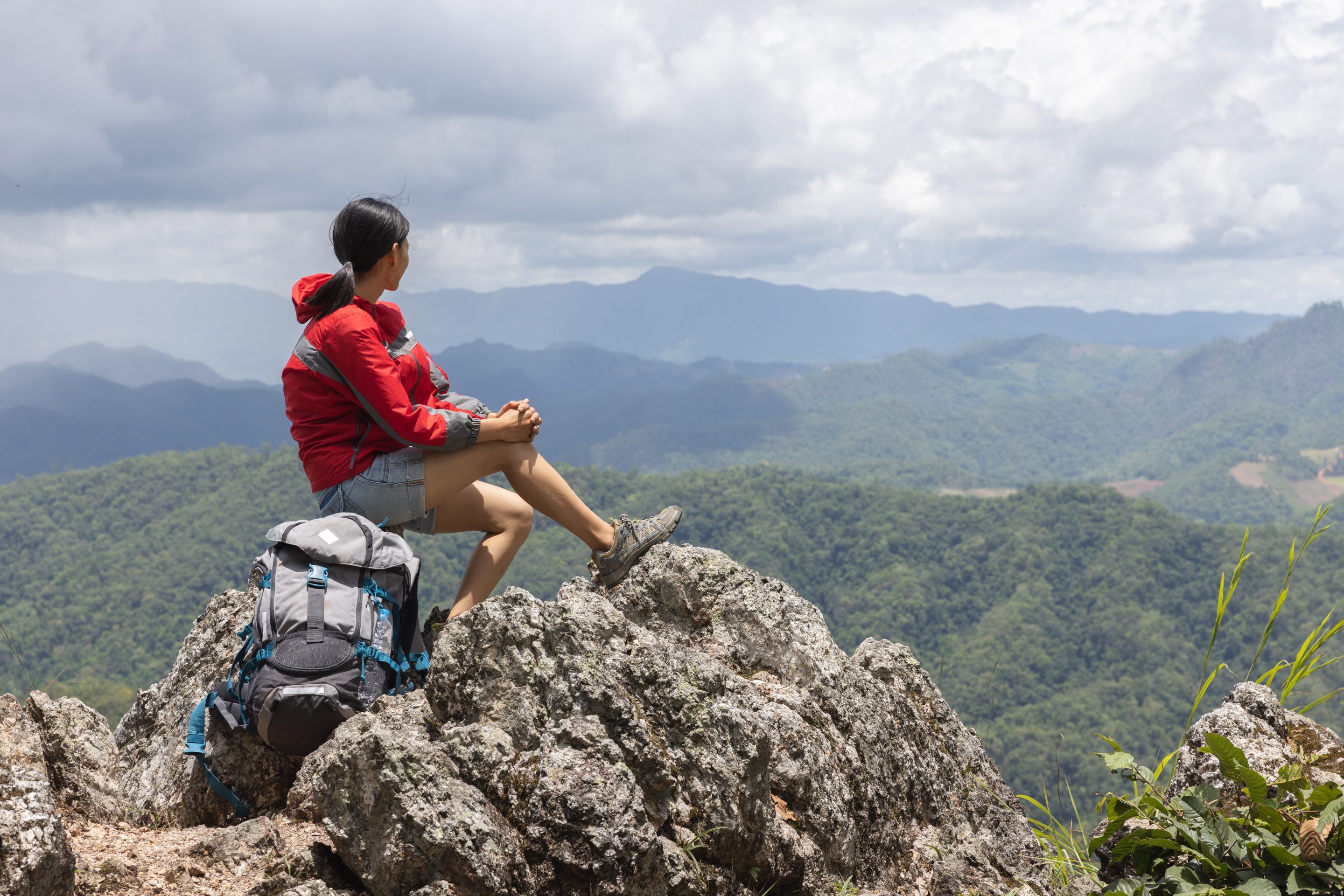 Jeune femme voyageuse avec un sac à dos élégant regardant vers l'avant la vue des montagnes. Profiter de la nature, se détendre, se faire plaisir. Activité physique régulière